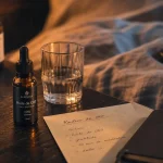 Huile de cbd pour dormir, flacon ambré sur table de nuit