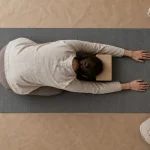 Position de l’enfant yoga : front au sol sur brique, genoux souples